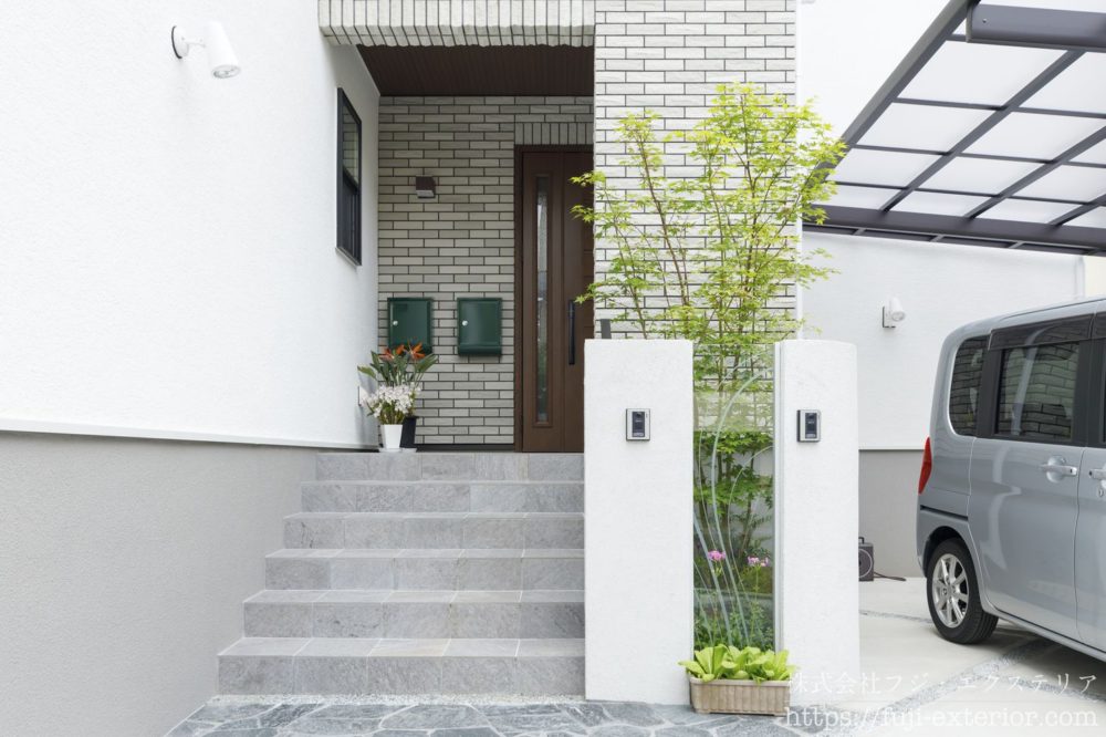 二世帯住宅・新築一戸建ての外構デザイン、大阪府の施工事例です。門柱にはEXALIVE ガラスパネルを挟み、後ろの植栽が見えるデザインになっています。