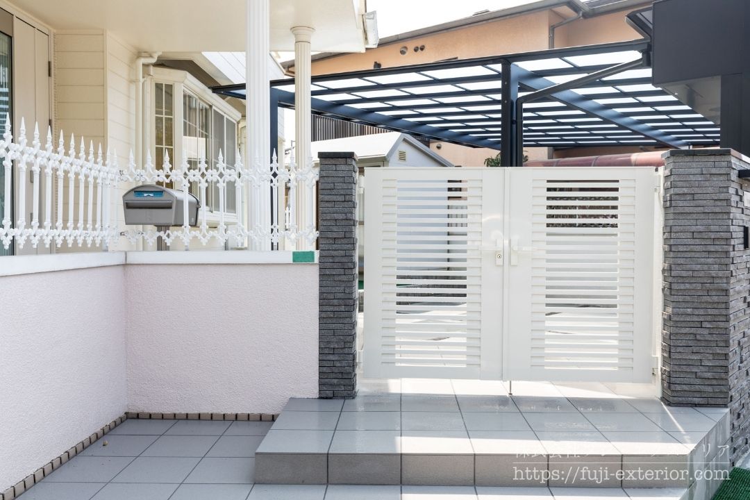 LIXIL 門扉 ライシス9型: ほどよい透け感のあるLIXILのアルミ形材門扉「ライシス9型」のエントランス。
雨に濡れずに郵便物が取り出せるよう、フェンスを切り抜き加工して設置したポスト。