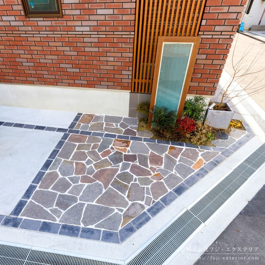 1台用駐車スペースの床は、アクセントにナチュラルカラーの乱形石を張りました。