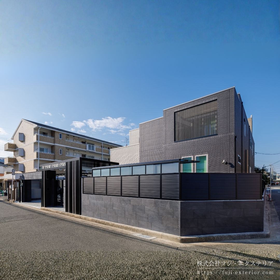 門まわりの壁には、シックなグレーのタイル ノルディックストーン を使用。重厚感のある邸宅の雰囲気に合わせてエレガントに仕上げました。 外周は LIXIL ABフェンスでしっかり目隠してプライバシーを守ります。一部土留めが必要で太陽エコブロックス CP型枠化粧ブロックを積みました。