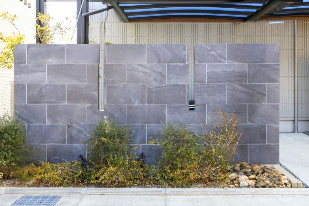 高級感のあるグレーのグラデーションタイルを使用した目隠し塀の施工事例。駐輪スペース前に設けることで、雑多になりやすい自転車置き場を視線から遮り、上品で洗練された外構デザインを実現。