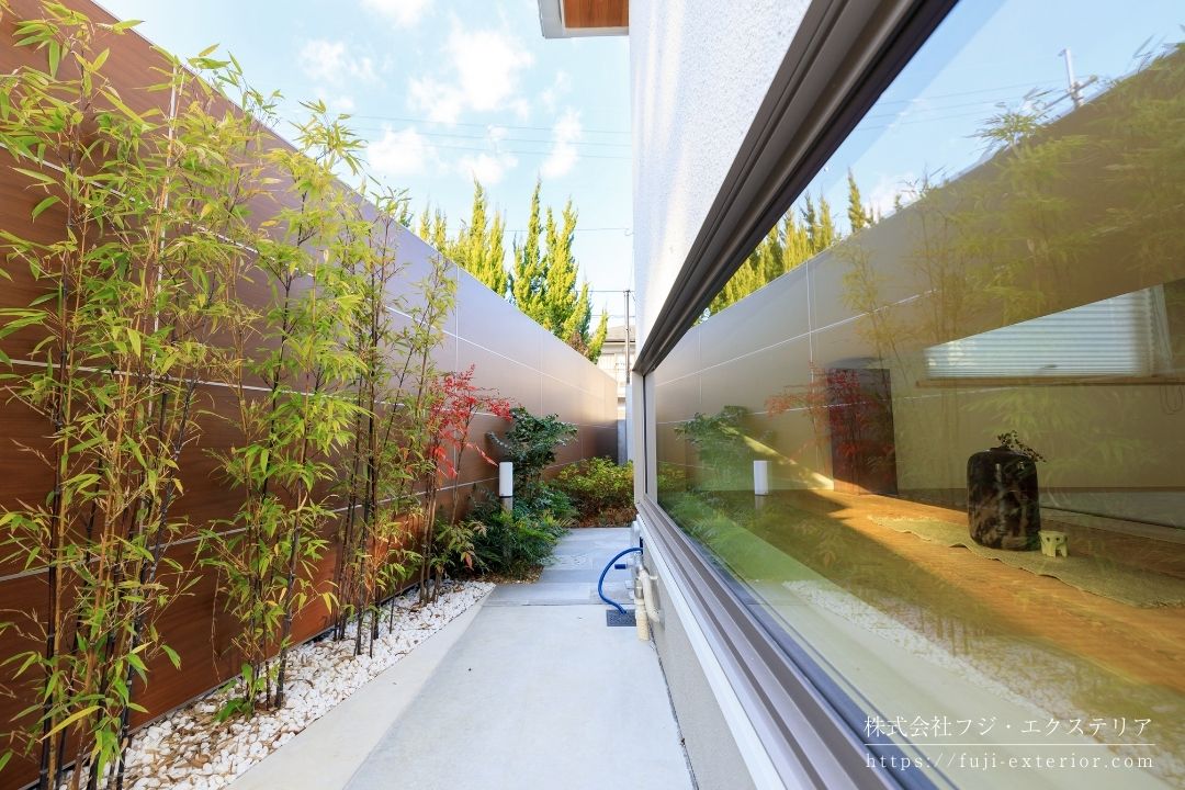 和室の腰窓から見える小庭は、木目調の目隠しがあり、手前にはクロチクを植えました。