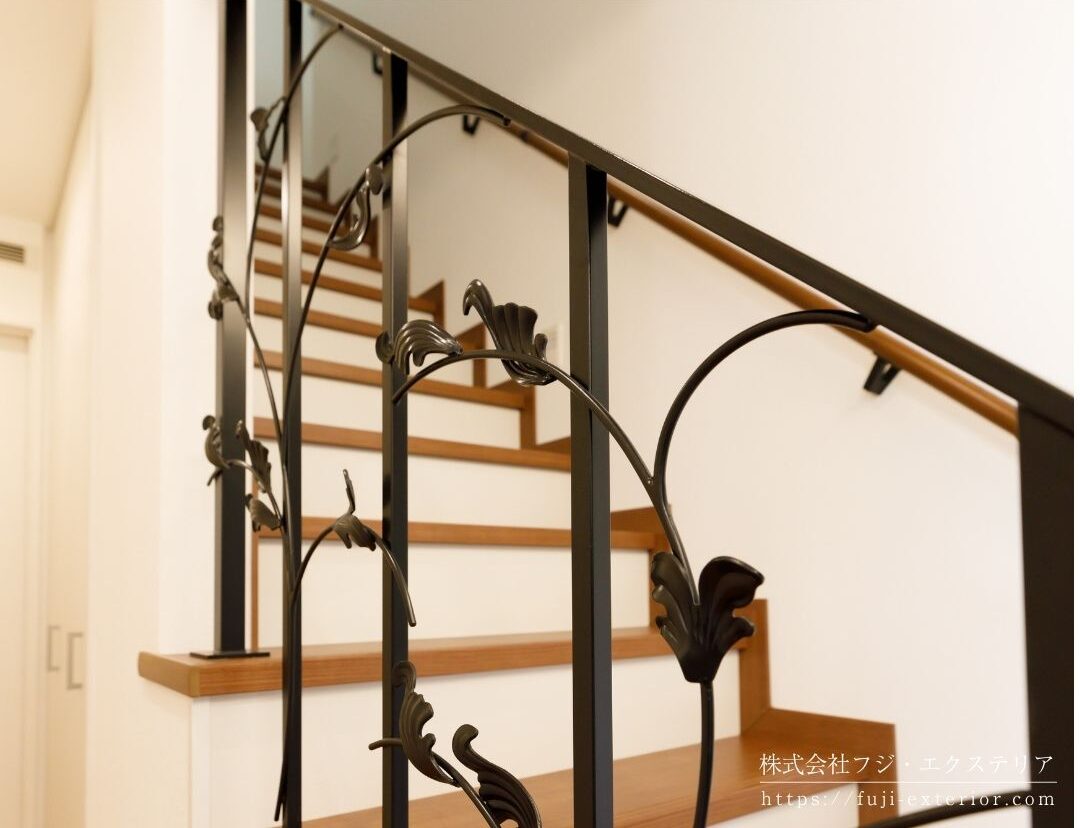 玄関を開けたらすぐ目に入るフルオーダーメイドのアイアン製手すり(大和金属工業製)。奥様こだわりのリーフモチーフが素敵です。