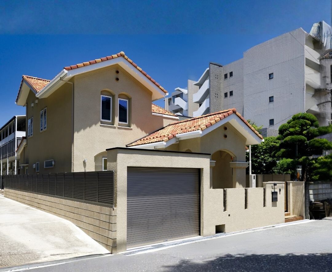 ハイドロテクトタイルや瓦の色味と外構素材を統一。豊中市で定評のある、建物と庭が一体となった美しいスパニッシュエクステリア。外部からの視線を遮りつつ、意匠性を損なわない門まわり設計。