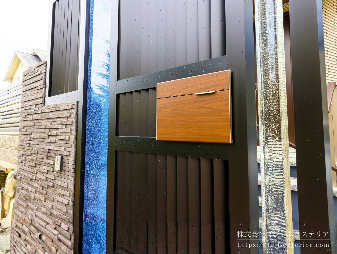 新築外構の施工実例・大阪。プラスGで造ったエントランスアーチ。ポスト、表札など門周りに必要なものをすべて組み込み、ブルーの大型エクステリアガラスをアクセントにしています。