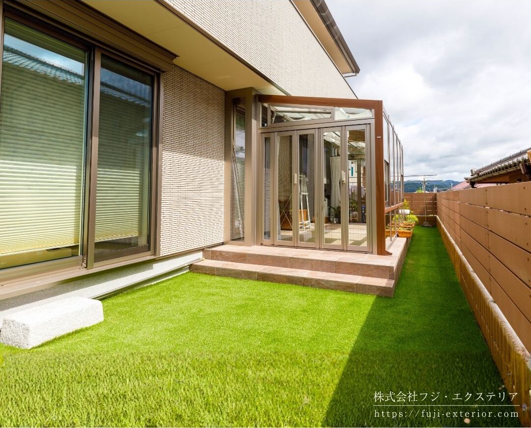 ガーデンルーム LIXIL ココマⅡ。左右側面は折れ戸仕様で前面は強化FIXガラス。換気用の上げ下げ窓、側面喚気窓、内部日除け、ロールカーテン、LEDスクエアライト、可動竿掛け付きのフル装備バージョンです。