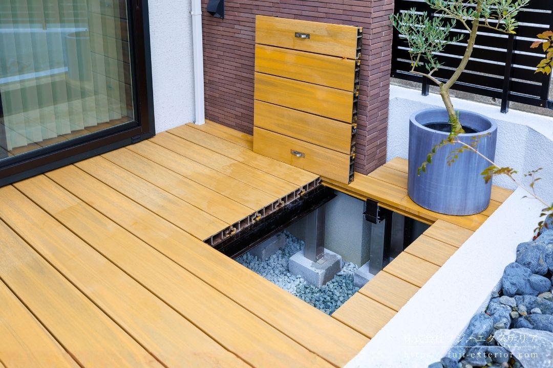 デッキテラスには大きめの点検口を設置。通常40cm角ですが、60cm角にしました。下に空きスペースがあるので、濡れてもいい物を収納する場所として活用できます。デッキの下は雑草対策として防草シート＆砂利を敷き詰めました。