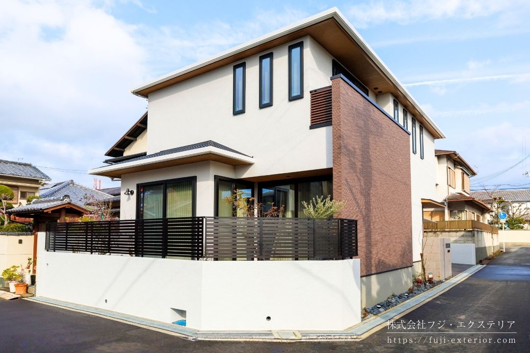 境界塀は ブロック控え壁不要の6段積みにし、スタッコ色合わせ トラバーチン仕上げで塗装。フェンスは LIXILフェンスAB ブラックですっきりシンプルに。適度なスリットが上品で、圧迫感もなく光と風も通します。