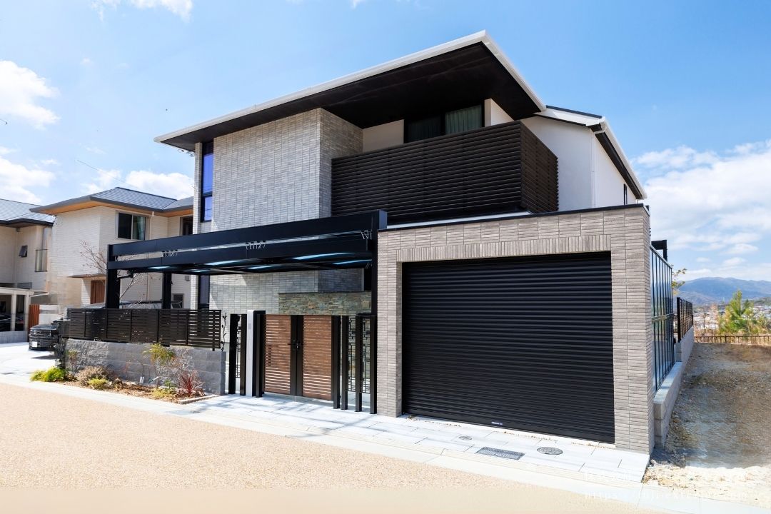 リフォーム後の写真。開放的なオープン外構を、プライバシー保護と防犯性を高めたクローズ外構にリフォームしました。建築の水平ラインを踏襲し、庭とガレージの空間に連続性を持たせるように、三協アルミ U.スタイルアゼストで全体をダイナミックに覆いました。