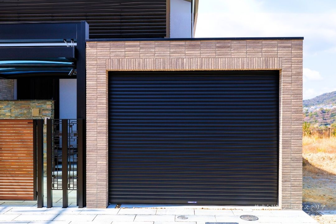 タイル張りゲートのシャッターガレージ。シャッターは三和シャッター工業のサンゲートR型 アルミスラットシャッターを使用。