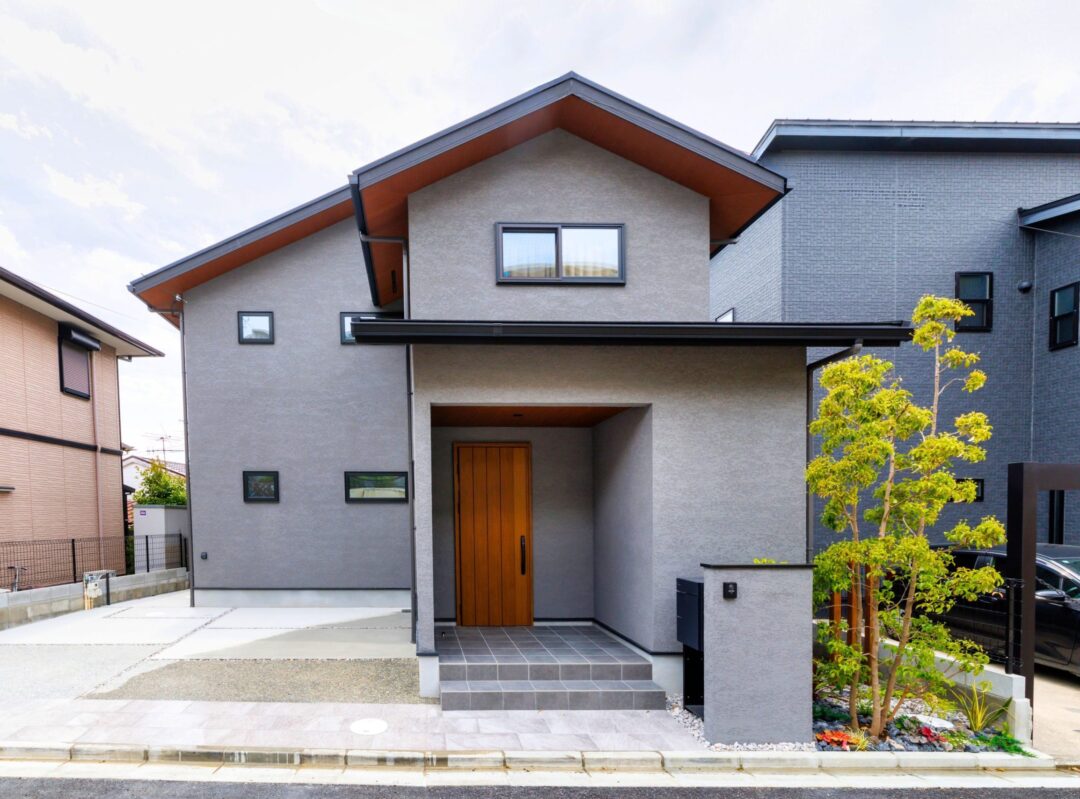 兵庫県の高級住宅街における新築オープン外構の施工例。広い間口を活かした2台駐車可能なガレージと植栽アプローチ。