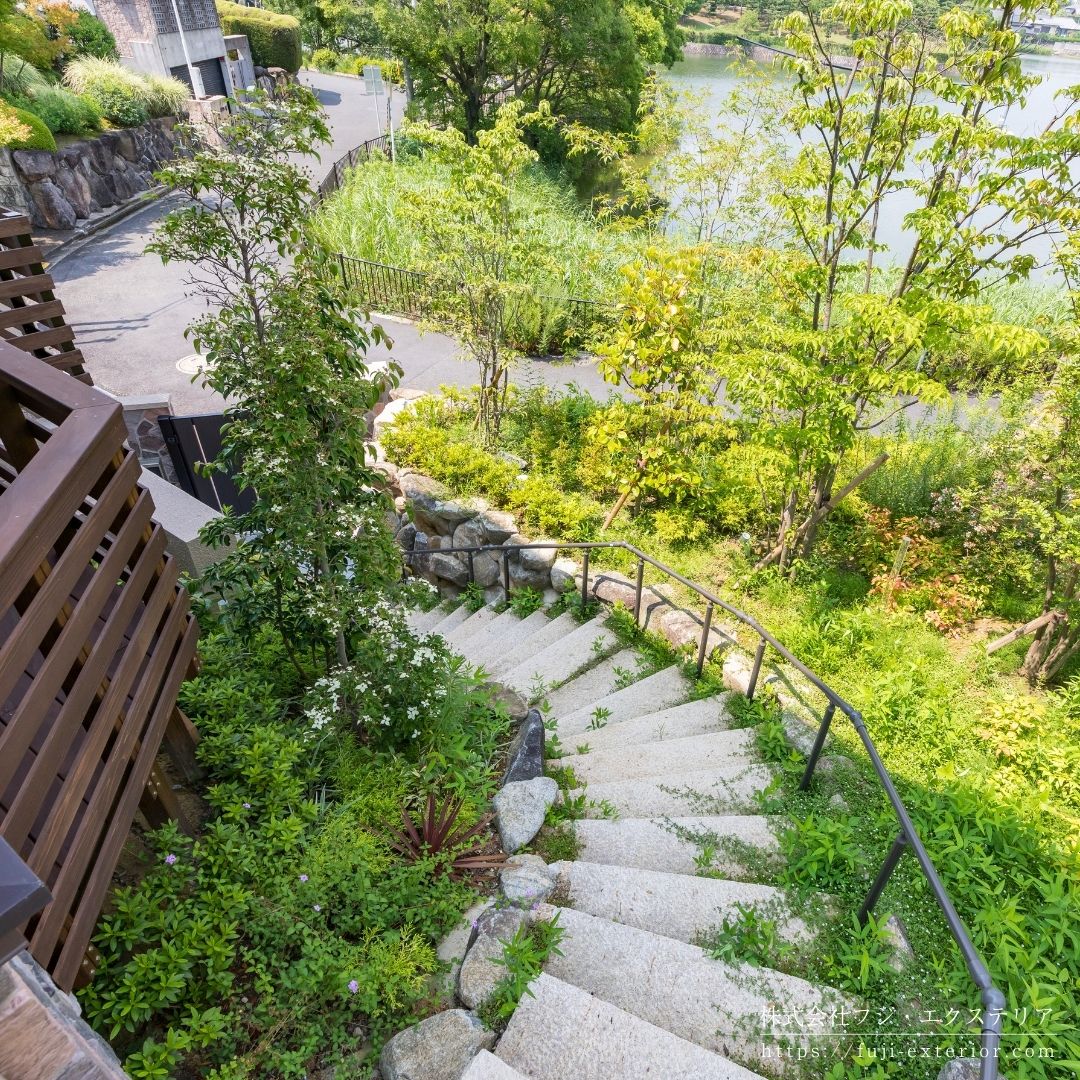 門を開けると石段のアプローチ。既存の生駒石に合わせた石積土留と、御影石の階段が森の中にいるような雰囲気。