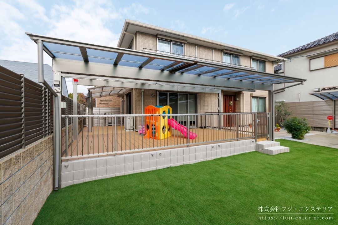 お子様の転落防止対策を施したL字型樹脂ウッドデッキの施工例。足をかけて登りにくい縦格子フェンスとブロック塀で囲い、安全性を確保した大阪の戸建て住宅のお庭リフォーム。