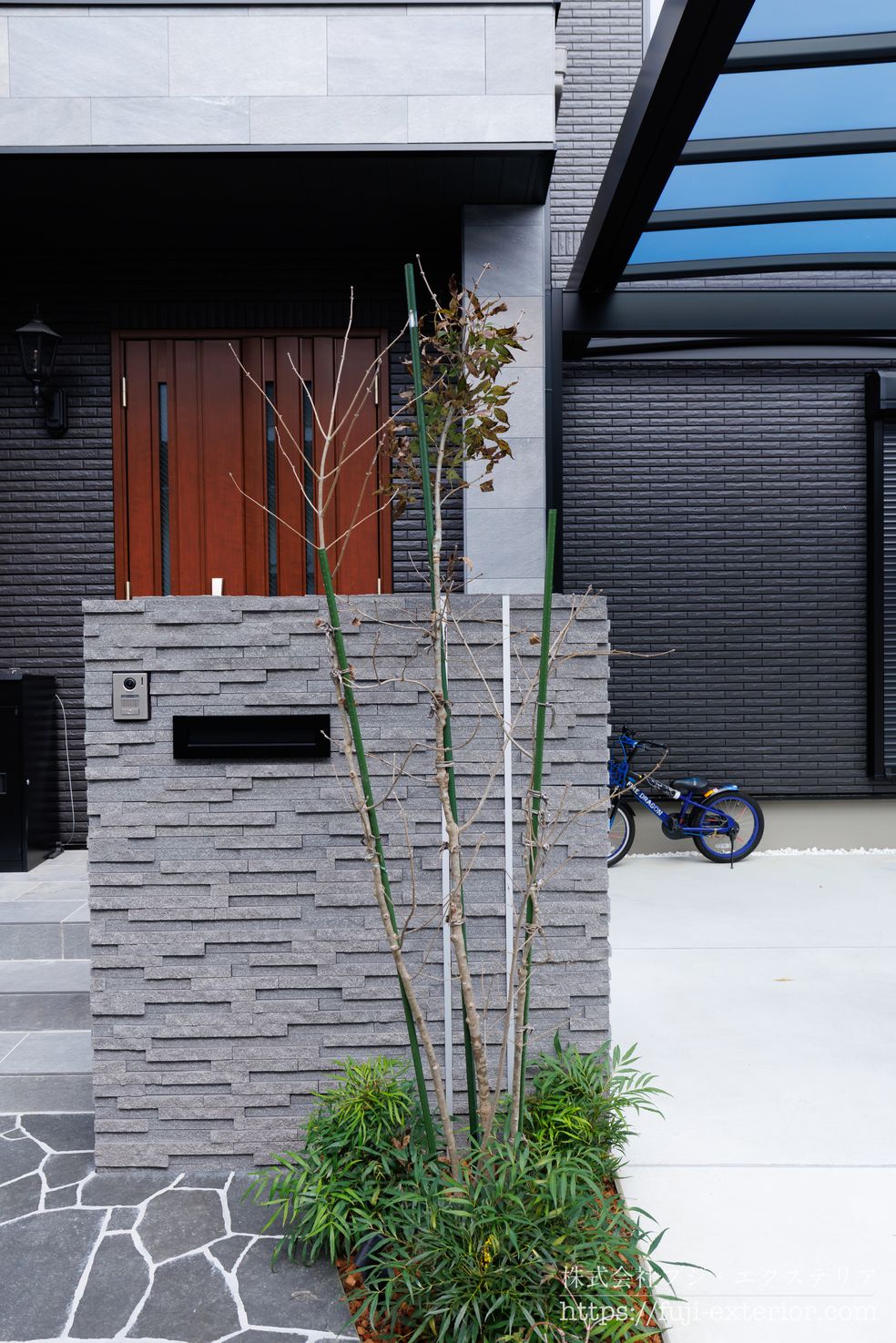 家の顔となる門柱廻り。門柱は凸凹模様のグレータイルを張り、存在感を出しました。