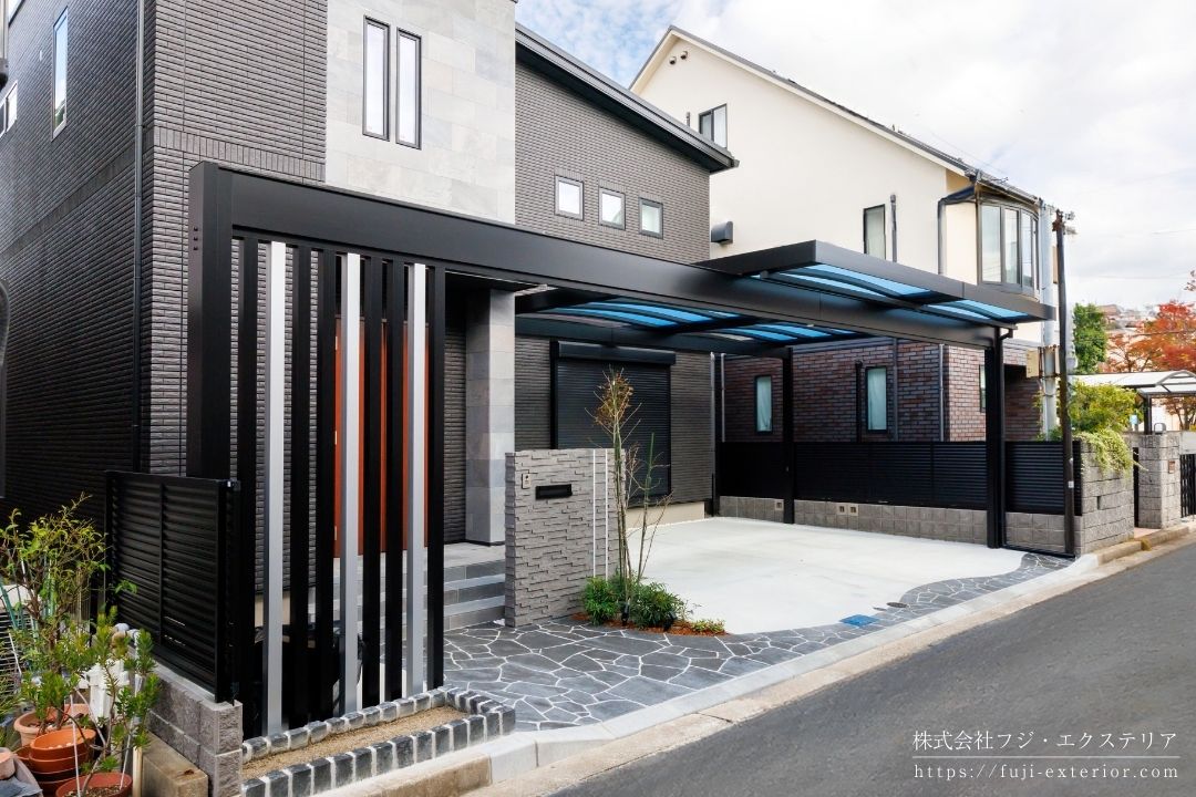 ファサード空間全体を整える全長12mフレームのカーポート屋根は三協アルミ U.スタイルアゼスト・梁延長納まり。ブラック&シルバーのモノトーン配色で住宅ともシックに調和しています。